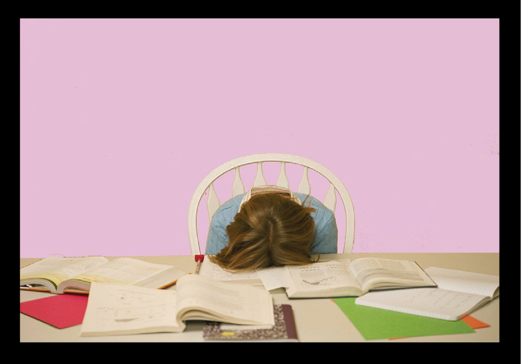 Stressed student with head down on desk surrounded by open books and study materials, showing exam pressure and fatigue." calm